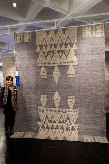 Teresa Roberts, Jaipur Living’s Director of National Sales, next to the Rize Torsby rug.