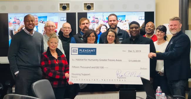 Rion Morgenstern (Far Right), president and CEO, presenting the Habitat for Humanity board with the donation.