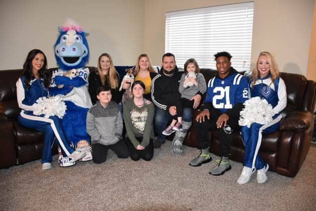 The Sawyer family, together with Indianapolis Colts’ RB Nyheim Hines (wearing his jersey), cheerleaders, and team mascot “Blue”, enjoy their new living room furniture, courtesy of Bob’s Discount Furniture.