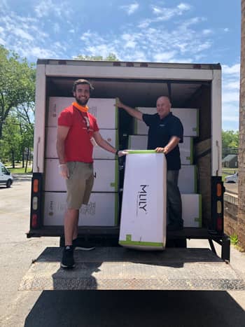 Ian Ennis with the J.A. Henry Community YMCA in Chattanooga accepts a load of mattresses from MLILY USA’s Gregg Layne that were donated following a line of tornadoes that ripped through Chattanooga Easter Sunday.