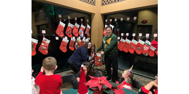 MILY USA employee Courtney Ferrell with her goddaughter, who won the best decorated stocking contest, and Stephen Chen, president, MLILY USA.