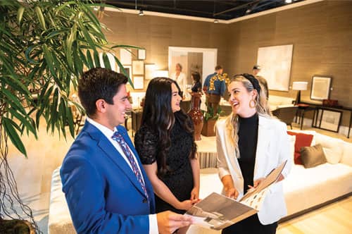 Pictured from left are students Jake Pardi and Abigail Peterson, with Alexa Keaney, communication and events coordinator for Baker McGuire, sharing the company’s brochure with students who were working at the market. 