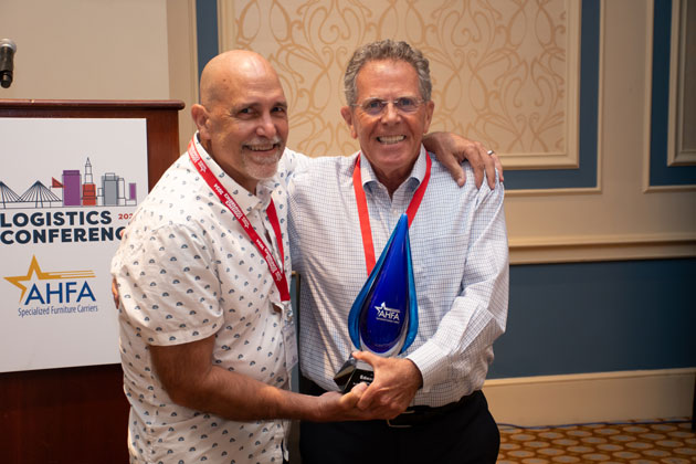 Edward Massood (right), president of Massood  Logistics, receives the Specialized Furniture  Carriers 2024 Lifetime Achievement Award from  Mike Padjen of the American Home Furnishings  Alliance. (Photo: Michele Morris).